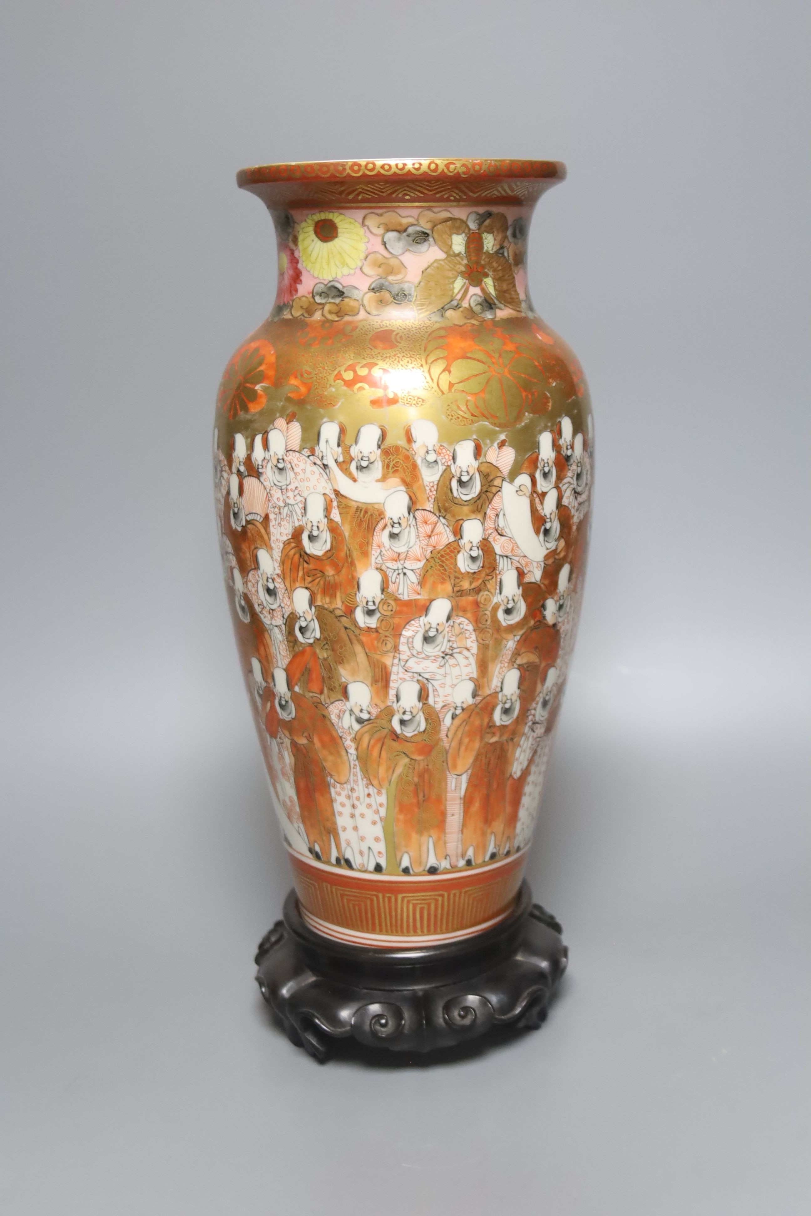 A tall Japanese Kutani porcelain vase, decorated with Rakan, 30cm, wood stand